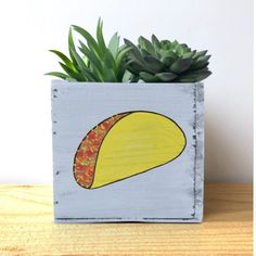 a small planter with a taco painted on it