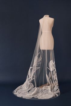 a wedding veil on a mannequin's dummy is shown in front of a dark background