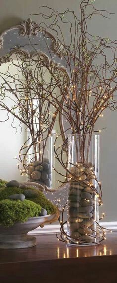 a vase filled with branches and rocks on top of a table