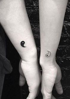 two people with matching tattoos on their arms holding each other's hands, one has a crescent and the other has a half moon