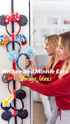 two women looking at mickey and minnie ears on a refrigerator