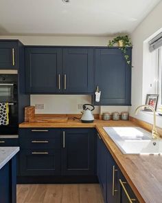 a kitchen with blue cabinets and wooden counter tops