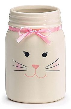 a white cat jar with a pink bow on it's head is shown in front of a white background