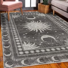 a large rug with sun and moon designs on it in a living room area next to a couch