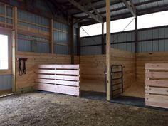 the inside of a barn with wooden stalls