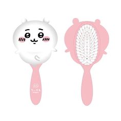 two pink hair brushes sitting next to each other on top of a white surface and one has a cat's face drawn on it