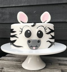 a cake decorated to look like a zebra's face with ears and eyes painted on it