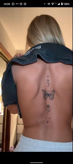 the back of a woman's body with a butterfly tattoo on her left side