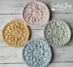 three crocheted coasters sitting on top of a white wooden table next to each other