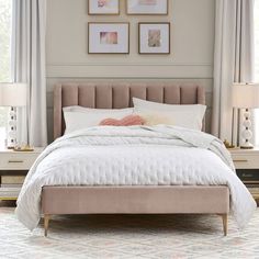 a bed with white sheets and pillows in a bedroom next to two framed pictures on the wall