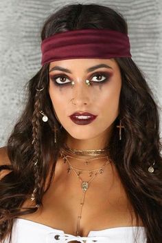 a woman with long hair wearing a white top and purple headband, posing for the camera