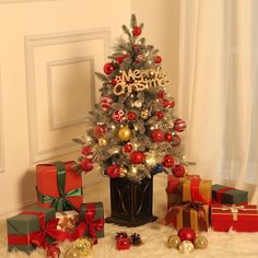 a small christmas tree with presents around it