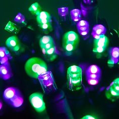 a bunch of lights that are on top of each other in the dark, with green and purple lights around them