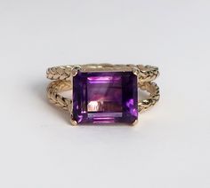 "This is a version of a ring I originally made as a custom project, commisioned by my brother-in-law as a gift for his wife Gail. Recently a friend gave me a small parcel of antique 18th Century amethysts (Georgian Era I think), several of which fit this setting pefectly. With Charles' and Gail's blessings I am adding the \"Gail Ring\" to my line. The braids that form the band and the basket setting that cradles the genuine vintage Amethyst are solid cast 10k yellow gold. The amethyst measures 8 Handmade Fine Jewelry Amethyst Ring For Formal Occasions, Heirloom Style Amethyst Ring With Emerald Cut Gift, Heirloom Amethyst Solitaire Ring, Heirloom Amethyst Ring With Emerald Cut As Gift, Heirloom Amethyst Ring With Emerald Cut Perfect Gift, Heirloom Style Emerald Cut Amethyst Ring As Gift, Handmade Formal Fine Jewelry Amethyst Ring, Handmade Amethyst Ring For Formal Occasions, Luxury Handmade Amethyst Ring For Anniversary