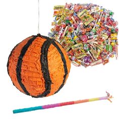 an orange ball and some candy sticks on a white background