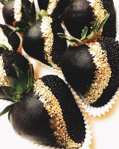 chocolate covered strawberries with gold sprinkles on them