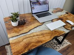 a laptop computer sitting on top of a wooden desk next to a keyboard and mouse