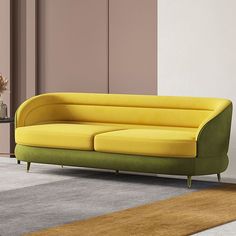 a yellow and green couch sitting on top of a rug next to a vase filled with flowers