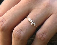 a woman's hand with a ring on it and three small flowers in the middle