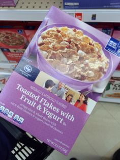 a box of toasted flakes with fruit and yogurt is held up