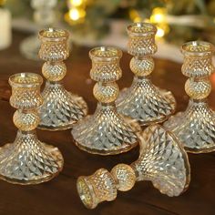 a group of crystal candlesticks sitting on top of a wooden table