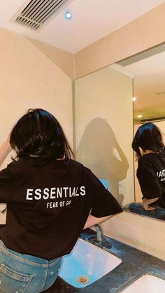 a woman is standing in front of a bathroom mirror