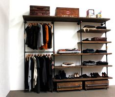 an organized closet with clothes, shoes and suitcases hanging on the wall next to it