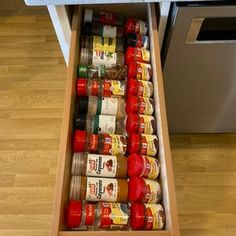 an open drawer in a kitchen filled with spices