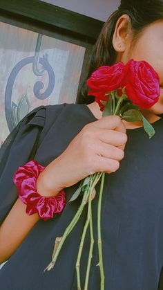 a woman is holding roses in her hands