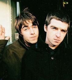 three young men standing next to each other in front of a door with their fingers up