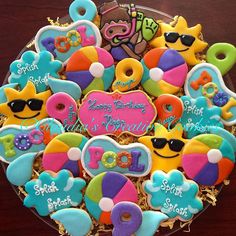 decorated cookies in the shape of heart, sun and sunglasses on top of a glass platter