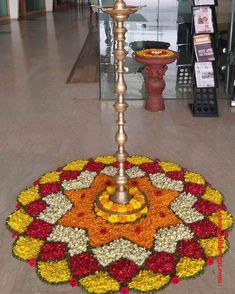 a large flower arrangement on the ground in front of a light pole with a candle