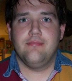 a close up of a person wearing a red shirt and yellow jacket with blue collar