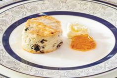 biscuits and butter on a plate with blue trimmings around the edges, including an orange jelly