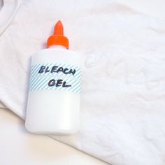 a bottle of bleach gel sitting on top of a white shirt