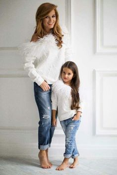 the mother and daughter are posing together for a photo in their white sweaters, jeans and heels