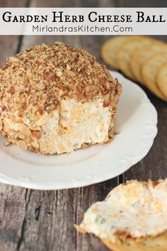 a white plate topped with cheese ball next to crackers