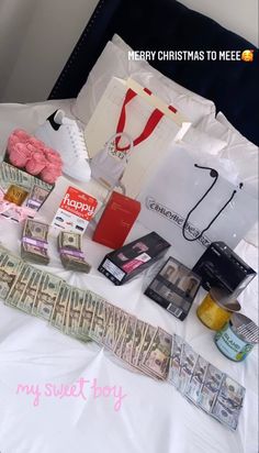 a bed topped with lots of money and other items on top of it next to a bag