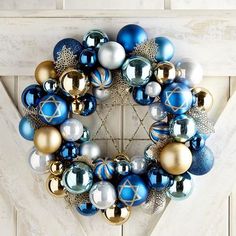 a blue and silver christmas ornament wreath on a door frame with ornaments around it