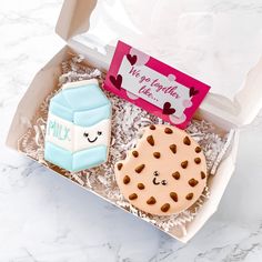 two decorated cookies in a box on a table