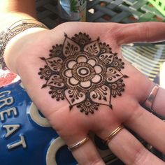 a woman's hand with a henna tattoo on it