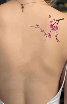 the back of a woman's shoulder with pink flowers on it