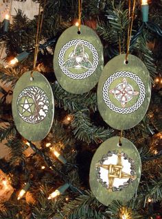 three ornaments are hanging from a christmas tree