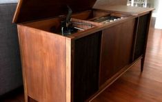 a record player sitting on top of a wooden cabinet