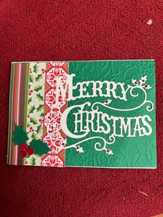 a merry christmas card sitting on top of a red blanket