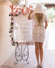 a woman standing next to a welcome sign