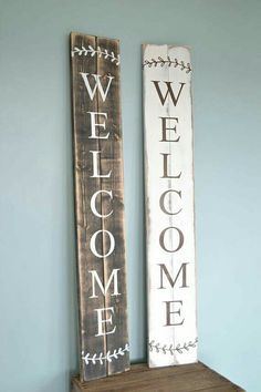 two wooden signs that say welcome and welcome are sitting on a shelf next to each other