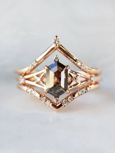 a gold ring with two different colored stones on top and one diamond in the middle