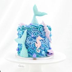 there is a cake decorated with blue icing and seahorses on the top