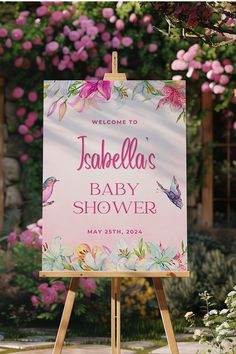 a welcome sign for a baby shower in front of pink flowers